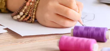 Une enfant dessine lors d'un atelier couture
