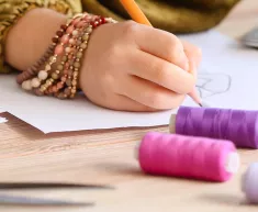 Une enfant dessine lors d'un atelier couture