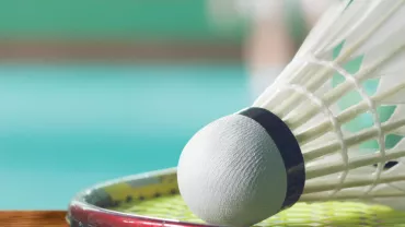 Volant de badminton posé sur une raquette © 