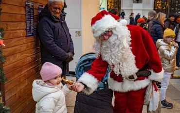 Le père Noël salue un petit enfant neuilléen croisé au marché
